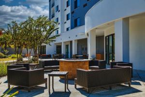 a patio with chairs and tables and a building at Courtyard Biloxi North/D'Iberville in Biloxi