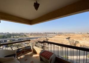 a balcony with chairs and a view of the city at Heliopolis pearl/ furnished apartment in Cairo