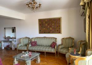 - un salon avec des chaises, un canapé et une table dans l'établissement Heliopolis pearl/ furnished apartment, au Caire