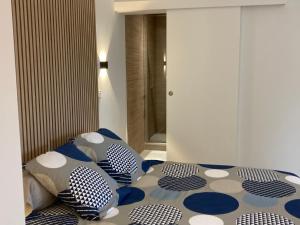 Schlafzimmer mit einem Bett mit blauen und weißen Kissen in der Unterkunft Studio au couleur de l’océan in Riantec
