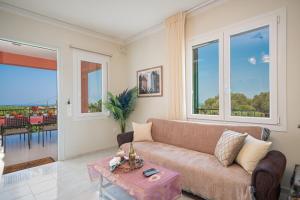 een woonkamer met een bank en een tafel bij Ariadni Sea View Apartment in Minia