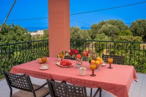 a table with food and fruit on a balcony at Ariadni Sea View Apartment in Minia