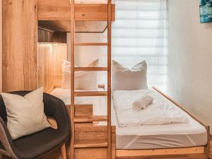 een kamer met een stapelbed en een stoel bij ZWEITE HEIMAT - AlpenLuxus Collection in Fügen