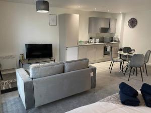 een woonkamer met een bank en een tafel met stoelen bij Beautiful 1 Bed Studio Apt in Central Manchester in Manchester