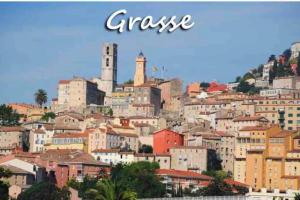 a view of a city with buildings on a hill at Rez de jardin de villa avec terrain et piscine in Grasse