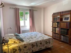 a bedroom with a bed and a book shelf at Rez de jardin de villa avec terrain et piscine in Grasse