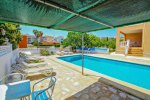 卡爾佩的住宿－Marlene - private pool villa with sea views from the rooftop in Calpe，一个带椅子和遮阳伞的游泳池