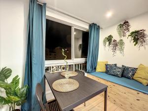 a room with a table and a couch and a window at Eros in Cap d'Agde