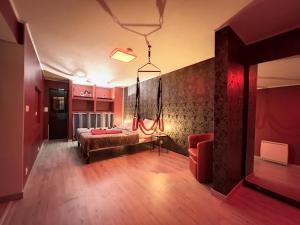 - une chambre avec un lit et un mur rouge dans l'établissement Eros, au Cap d'Agde