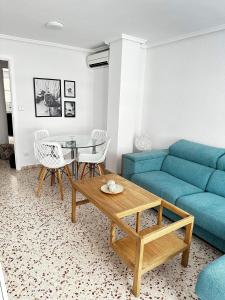 a living room with a blue couch and a table at Apartamento Mar y Arena in Cullera
