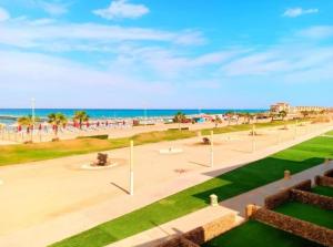 a view of a park with the beach in the background at شاليهات بورتو ساوث بيتش عائلات in Ain Sokhna