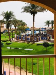 a view from a balcony of a resort with palm trees at شاليهات بورتو ساوث بيتش عائلات in Ain Sokhna