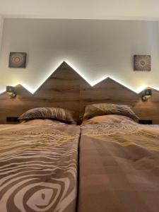 two beds in a bedroom with lights above them at Appartements Sonntal Einkehr in Fieberbrunn