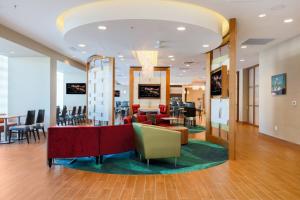 a lobby with a waiting area with chairs and tables at SpringHill Suites by Marriott San Jose Airport in San Jose