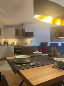 a wooden table with plates and bowls on top of it at Appartements Sonntal Einkehr in Fieberbrunn