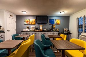 a restaurant with wooden tables and yellow chairs at Quality Inn & Suites in Tulare