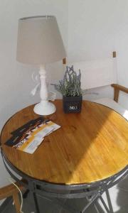 un tavolo con una lampada e una pianta in vaso di Casa Amarela Alojamento Local a Mértola