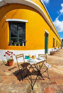 a table and chairs in front of a yellow building at Casa Amarela Alojamento Local in Mértola