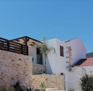 ein weißes Haus mit Steinmauer und Treppe in der Unterkunft Halepouri Apartment in Chania