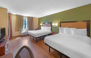 a hotel room with two beds and a television at Extended Stay America Suites - Kansas City - South in Kansas City