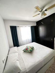 a bedroom with a white bed with a pillow on it at Apartamento Mar y Arena in Cullera