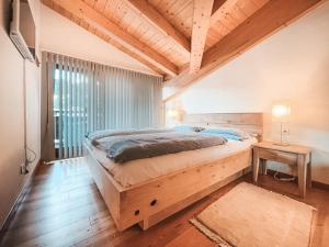 a bedroom with a large bed and a wooden ceiling at AlpenLuxus' LUNA with relaxation room, sauna & car park in Seefeld in Tirol