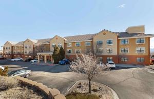 Extended Stay America Suites - Albuquerque - Rio Rancho في ريو رانشو: عمارة سكنية كبيرة مع موقف للسيارة