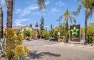 a sign in a parking lot with palm trees at Extended Stay America Suites - Los Angeles - Arcadia in Arcadia