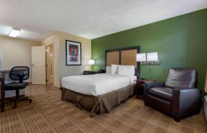 a hotel room with a bed and a chair at Extended Stay America Suites - Sacramento - White Rock Rd in Rancho Cordova