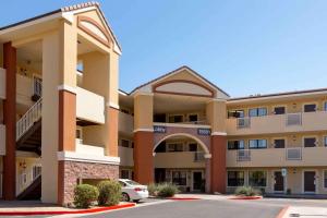 a large apartment building with a car parked in front at Extended Stay America Suites - Phoenix - Scottsdale - North in Scottsdale