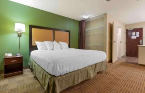 Un dormitorio con una cama grande y una pared verde en Extended Stay America Suites - Chicago - Schaumburg - I-90, en Schaumburg