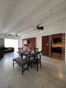 una sala da pranzo con tavolo, sedie e ventilatore a soffitto di Fresca estancia en zona Dorada con Alberca/Playa! ad Acapulco