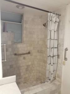 a bathroom with a shower with a white shower curtain at Fresca estancia en zona Dorada con Alberca/Playa! in Acapulco