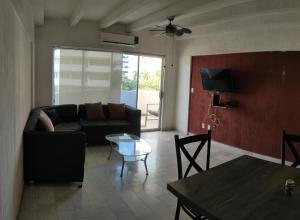 a living room with a couch and a table at Fresca estancia en zona Dorada con Alberca/Playa! in Acapulco