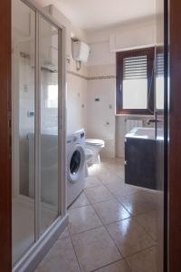 uma casa de banho com uma máquina de lavar roupa e um WC em Alloggio Alfa em Civitavecchia