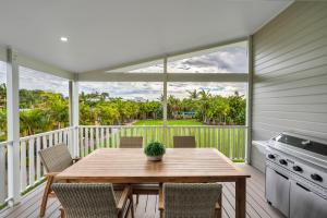 un portico con tavolo e sedie in legno sul balcone di Ingenia Holidays Soldiers Point a Soldiers Point