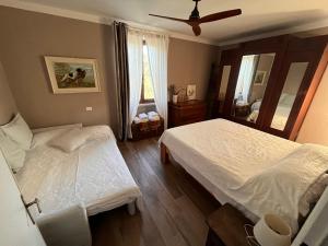 um quarto com 2 camas e uma ventoinha de tecto em Podere Orzale Agri b&b em Usigliano