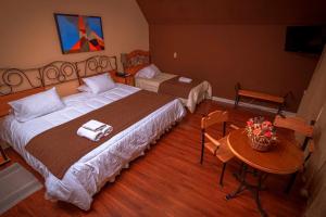 una habitación de hotel con una cama grande y una mesa en Hotel Inti Kuyen Plaza, en Pucón