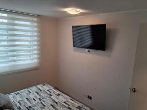 a bedroom with a flat screen tv on the wall at Departamentos Pilmaiquen in Padre Las Casas