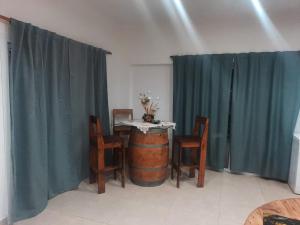 a dining room with a table and chairs and a barrel at Casa de Campo en Salta in Salta