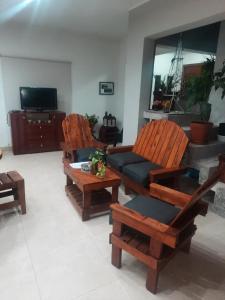 een woonkamer met 2 stoelen en een bank bij Casa de Campo en Salta in Salta