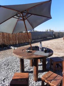 una mesa de picnic con una sombrilla en la playa en Casa de Campo en Salta en Salta