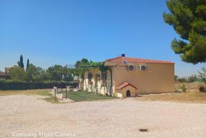 casa rural el mirador في Granja Arenales: منزل في حقل بجانب طريق ترابي