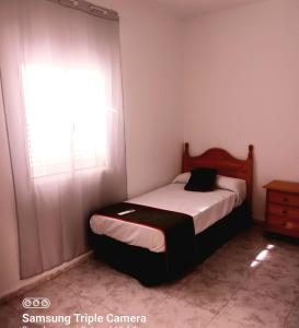 casa rural el mirador في Granja Arenales: غرفة نوم صغيرة بها سرير ونافذة