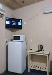 um quarto com um frigorífico e uma televisão na parede em Liart Hospedajes em Puerto Iguazú
