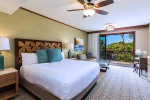 a bedroom with a large bed and a balcony at Koloa Landing Resort at Po'ipu, Autograph Collection in Koloa