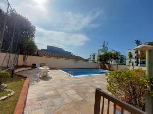 佩魯伊比的住宿－Apartamento Peruíbe，后院设有游泳池和围栏