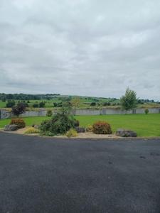 a parking lot with a field of grass and trees at Country Haven eircode H54 AK31 in Galway