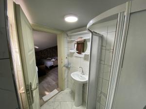 a small bathroom with a sink and a shower at Marina Hotel in Amasra
