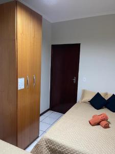 a bedroom with two beds and a wooden cabinet at Lindo quarto próximo ao metrô ! in Sao Paulo